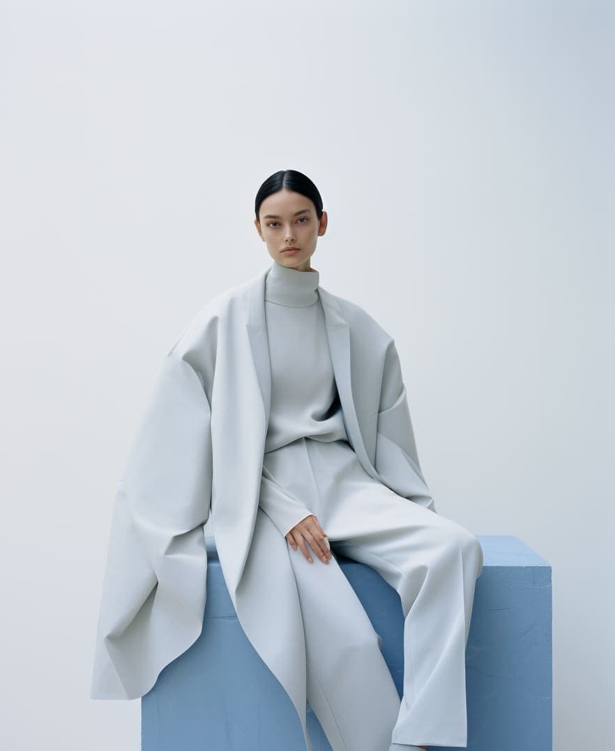 Midjourney prompt: a woman sitting on top of a white cube, official j...